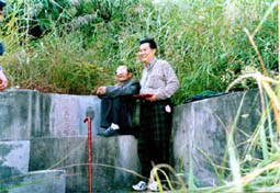 Master Tham with his master studying the fantastic Feng Shui of a grave yard while in China.